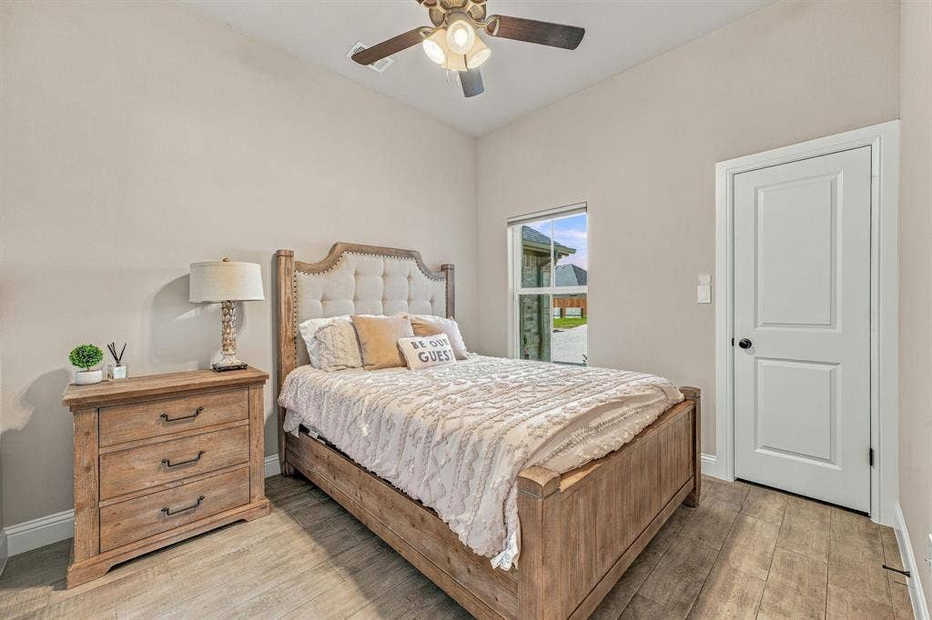 601 Violet Drive, Tolar, TX 76476 Wood-finish flooring throughout, vaulted ceiling, ceiling fan with integrated lighting, and a white paneled door