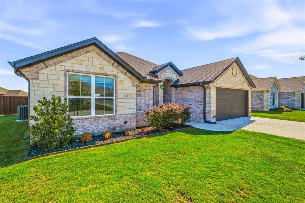 601 Violet Drive, Tolar, TX 76476 Stone and brick exterior with dark trim and a gabled roof