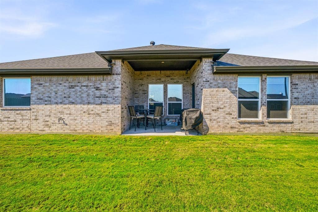 601 Violet Drive, Tolar, TX 76476 Brick exterior with a covered patio and multiple windows