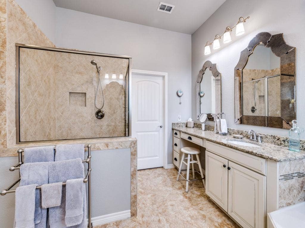 1220 Isabella Lane, Savannah, TX 76227 The spacious primary bath features split his-and-hers vanities, a relaxing garden tub, and a separate shower.