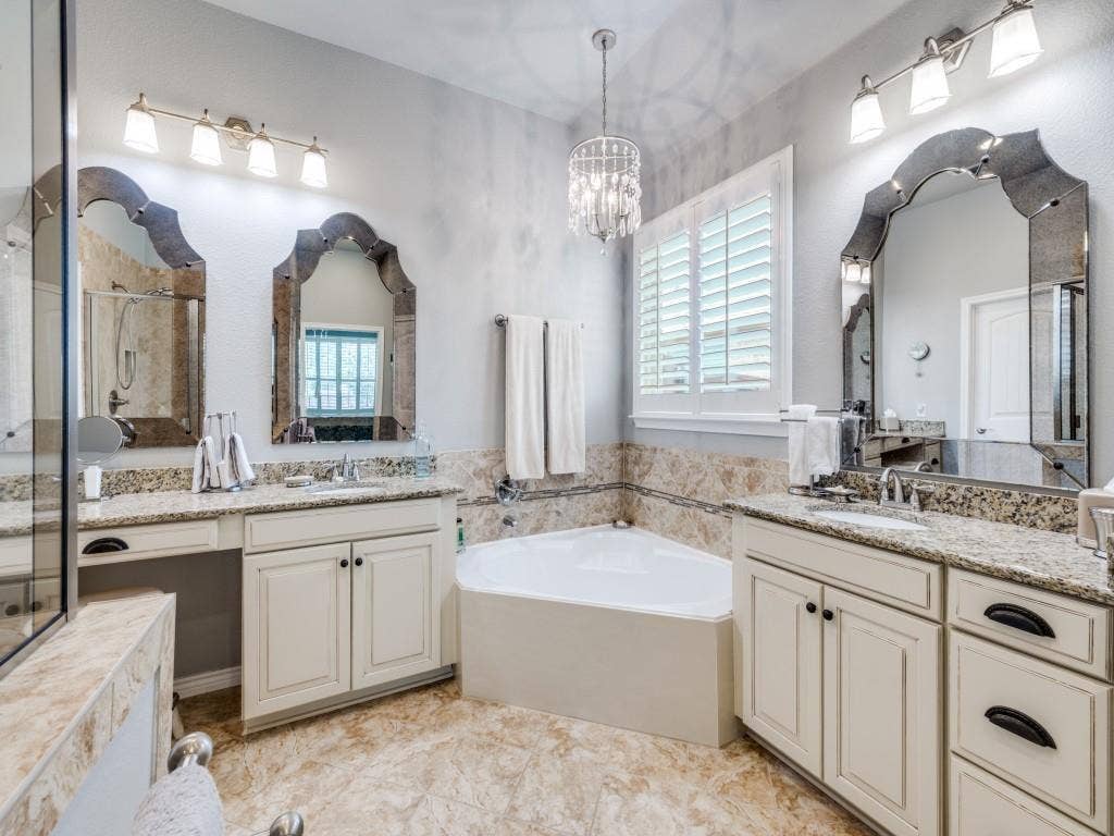 1220 Isabella Lane, Savannah, TX 76227 The spacious primary bath features split his-and-hers vanities, a relaxing garden tub, and a separate shower.