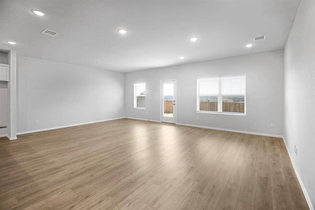 3517 Foxhound Lane, Denton, TX 76208 Recessed lighting, wood-finish flooring, white walls, multiple windows with blinds, and an exterior door