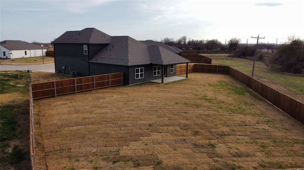 3517 Foxhound Lane, Denton, TX 76208 Expansive lot featuring a newly installed wooden privacy fence, a concrete patio, and a shingle roof