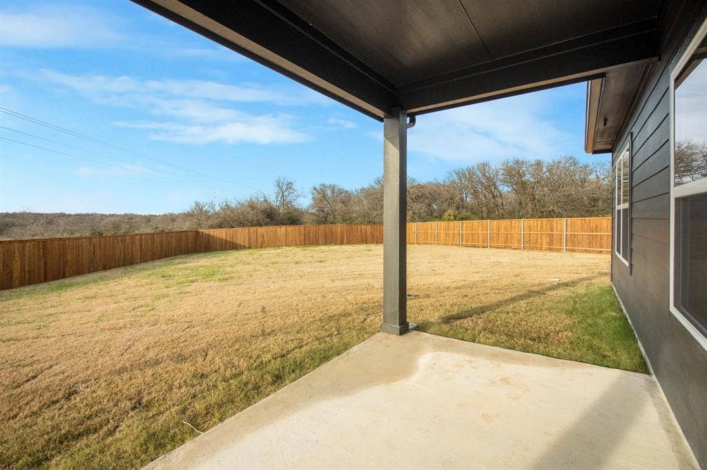 3517 Foxhound Lane, Denton, TX 76208 Expansive backyard featuring a wood fence, concrete patio, and covered patio area