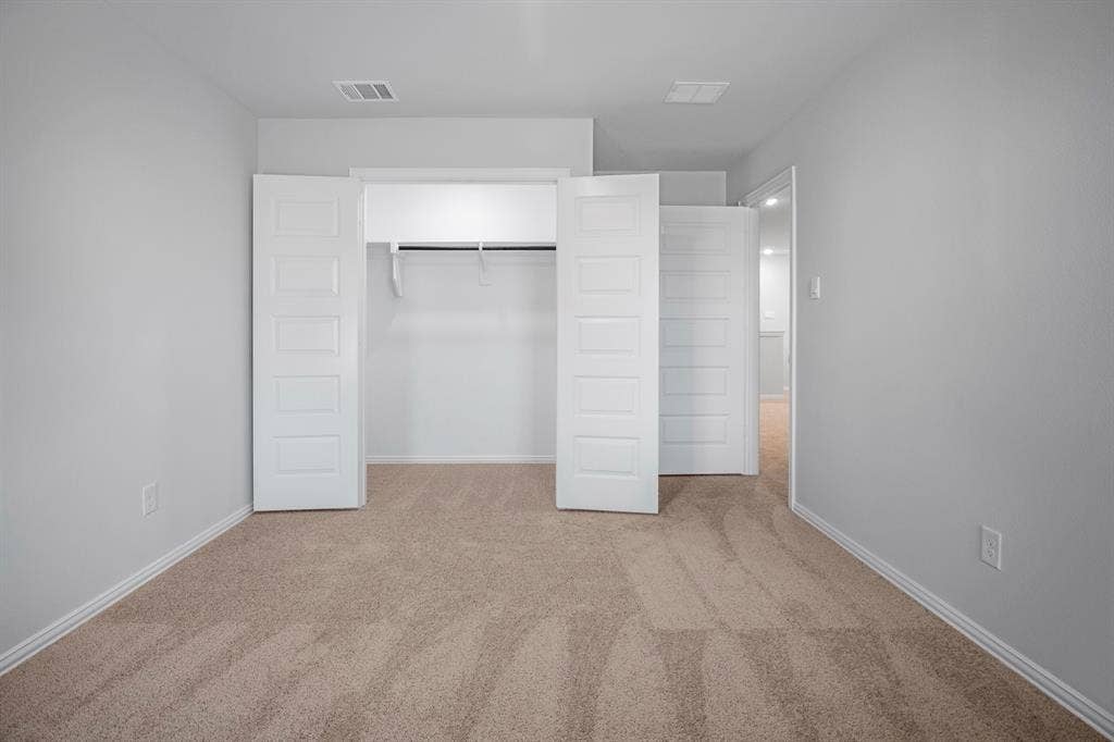 3517 Foxhound Lane, Denton, TX 76208 Carpeted flooring with light gray walls, featuring a closet with bi-fold doors and a hanging rod