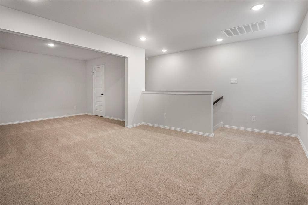 3517 Foxhound Lane, Denton, TX 76208 Recessed lighting illuminates the neutral-toned carpeted flooring and light gray walls