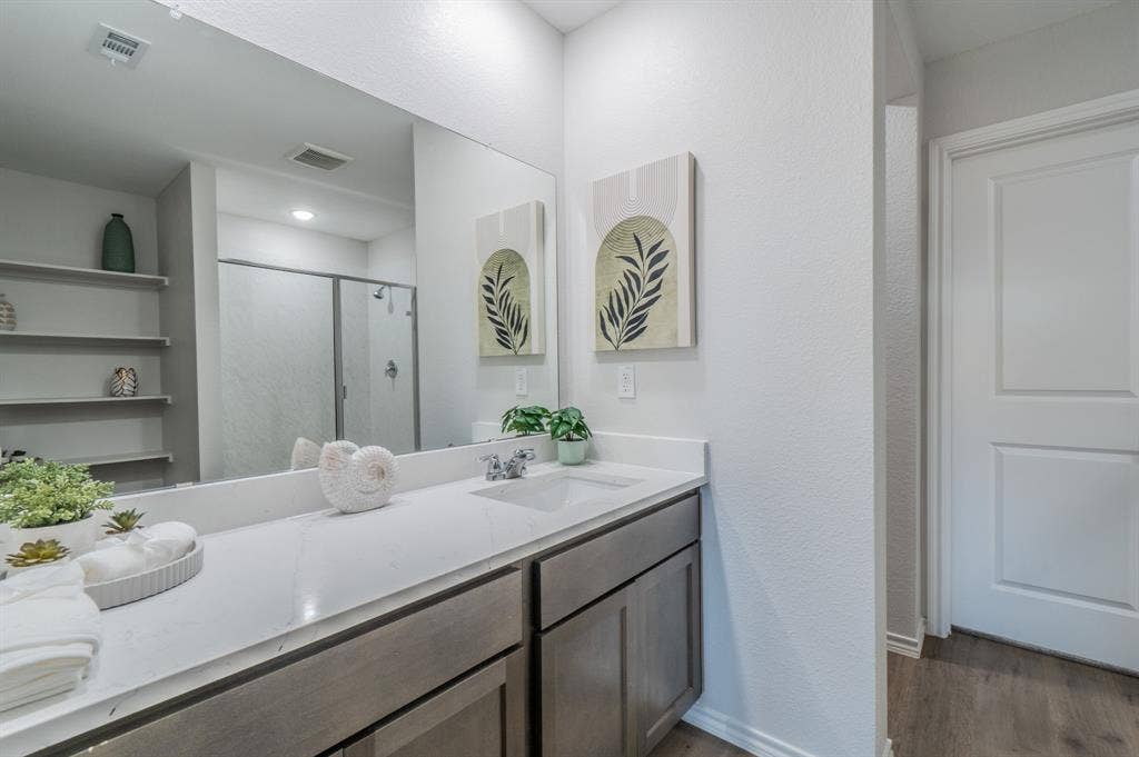 1842 Shady Elm Drive, Lancaster, TX 75146 Dual vanity with an integrated sink, polished chrome faucet, and gray wood-finish cabinetry