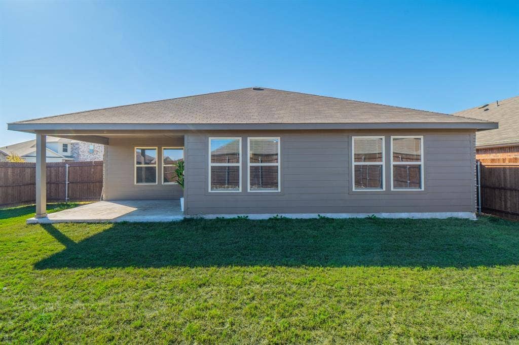 1842 Shady Elm Drive, Lancaster, TX 75146 Rear exterior featuring a covered patio, multiple windows, and a fenced perimeter