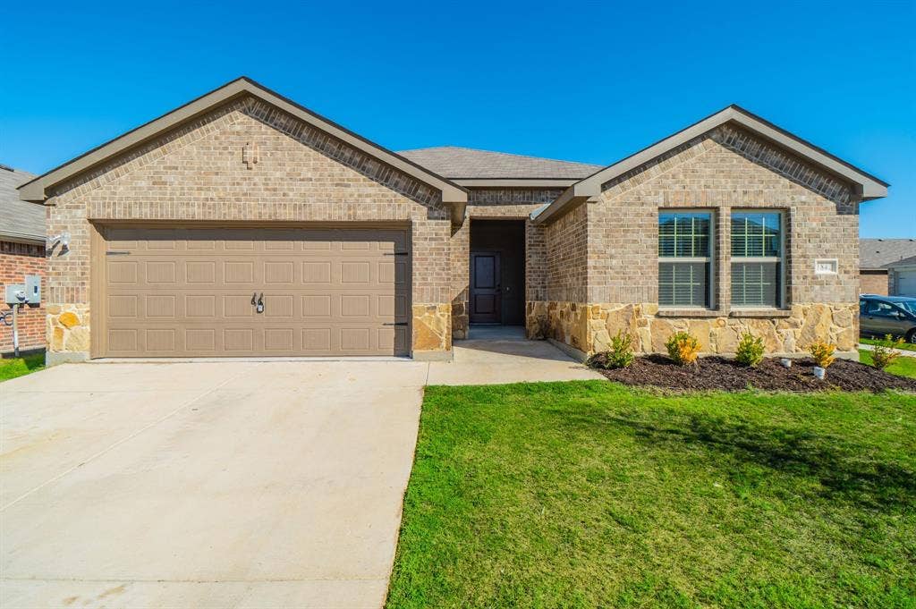 1842 Shady Elm Drive, Lancaster, TX 75146 Brick exterior with stone accents, an attached two-car garage, and a concrete driveway