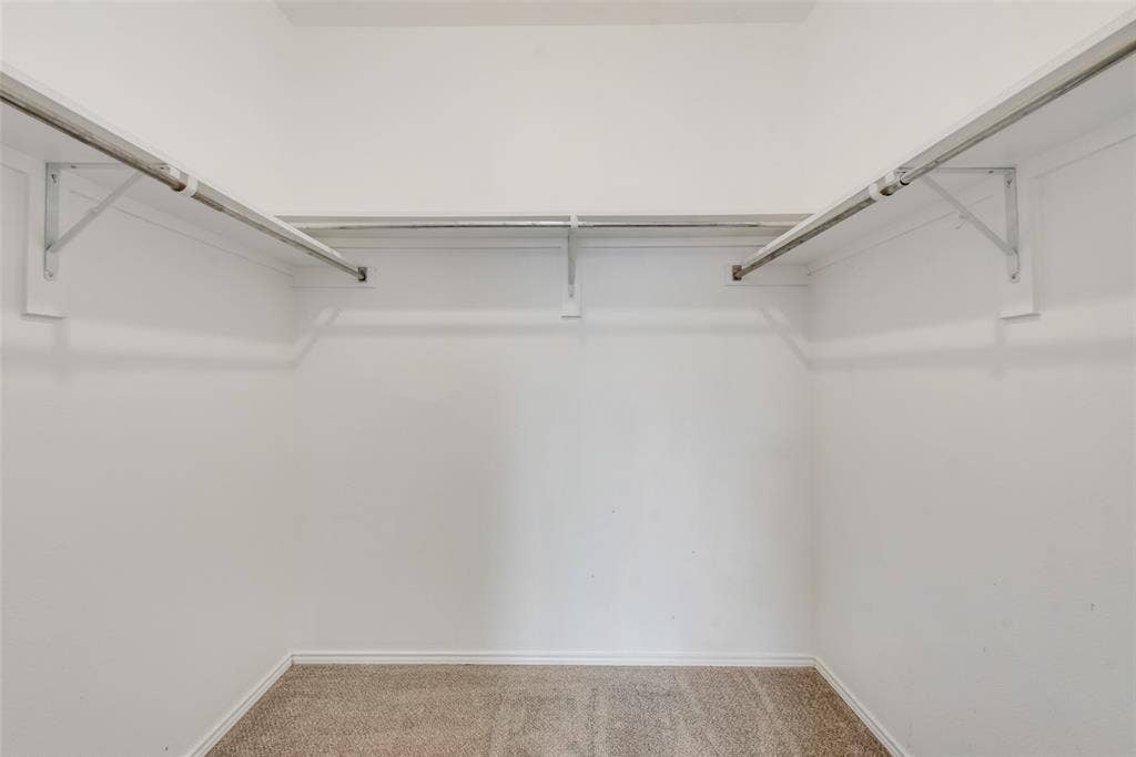 Built-in hanging rods, upper shelving, and carpeted flooring