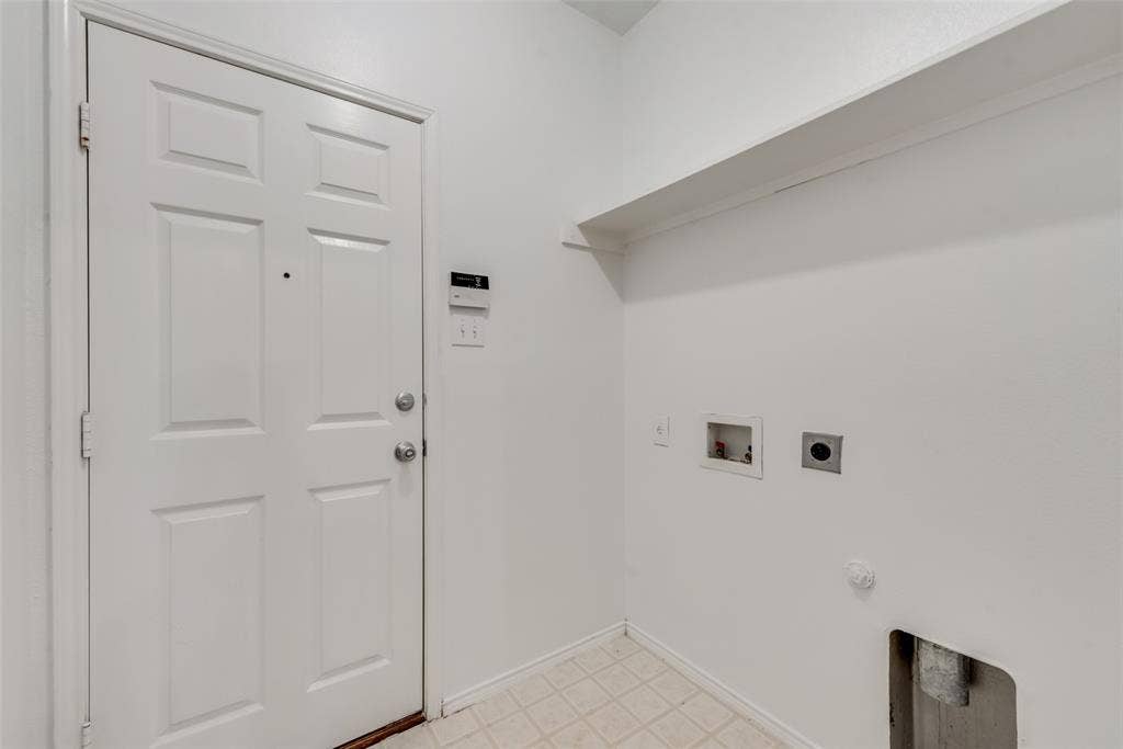 Utility space featuring a paneled door, built-in shelving, and vinyl flooring