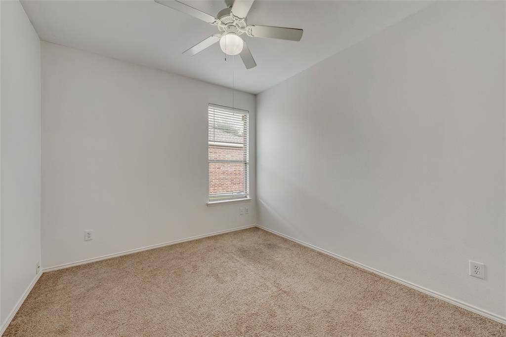 Neutral wall paint, ceiling fan with integrated lighting, window with blinds, and carpeted flooring