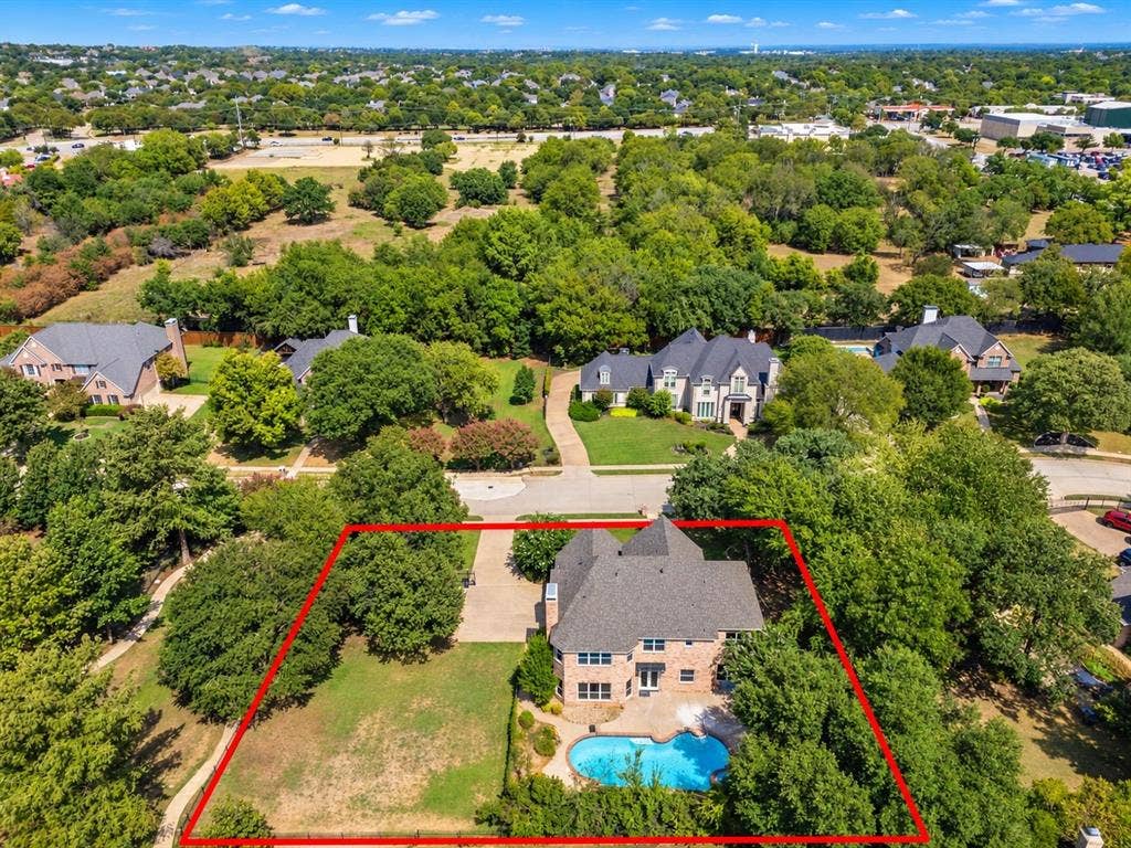 Two-story brick exterior with a gabled roof, large rear yard, and a swimming pool