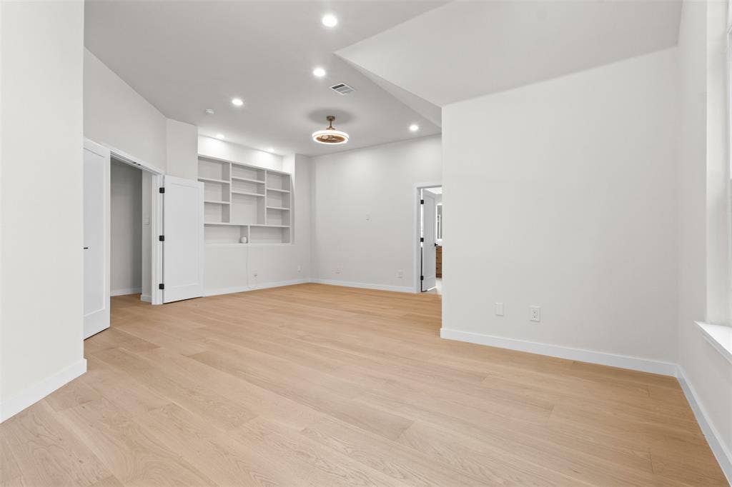 Light wood-finish flooring, recessed lighting, and built-in shelving
