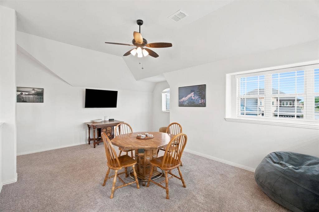 1218 Misty Ridge Drive, Justin, TX 76247 Carpeted room with a ceiling fan, sloped ceilings, and multiple windows