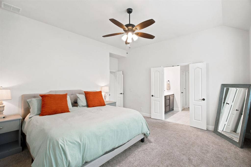 1218 Misty Ridge Drive, Justin, TX 76247 Vaulted ceiling with an attached ceiling fan, plush carpet flooring, and white paneled doors
