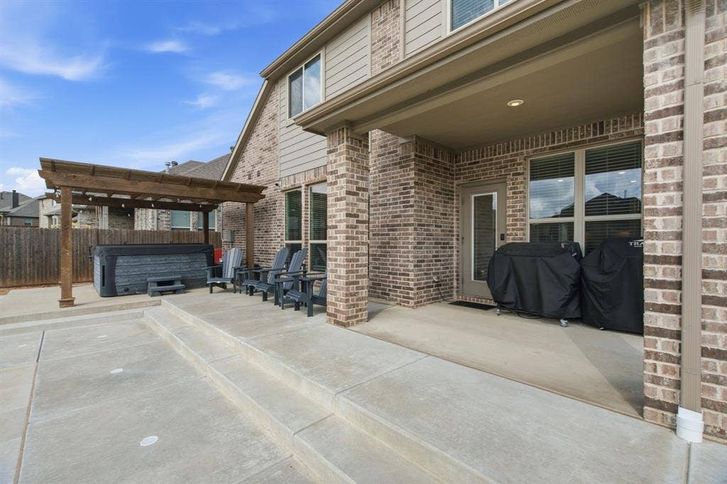 1218 Misty Ridge Drive, Justin, TX 76247 Expansive concrete patio with stepped design and a wood pergola