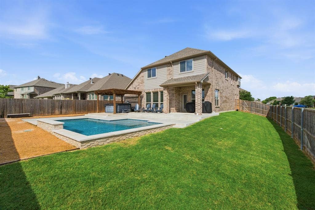 1218 Misty Ridge Drive, Justin, TX 76247 Expansive backyard featuring a rectangular swimming pool with stone coping, a spacious patio area, and a wood pergola and freestanding spa