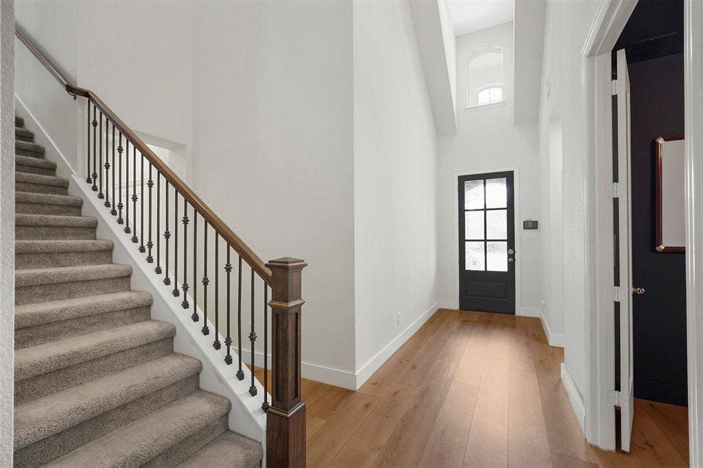 1506 Carnation Street, Celina, TX 75078 Two-story foyer with high ceilings, wood-finish flooring, and a black paneled door with frosted glass