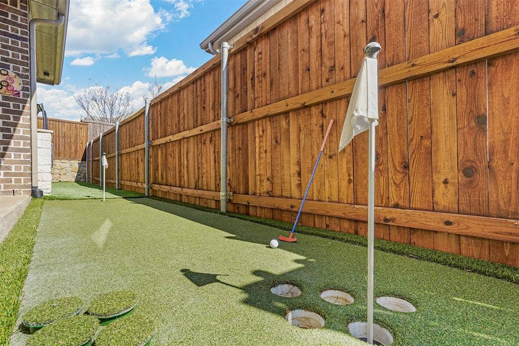 1506 Carnation Street, Celina, TX 75078 Putting green with artificial turf, wood fence, and brick exterior