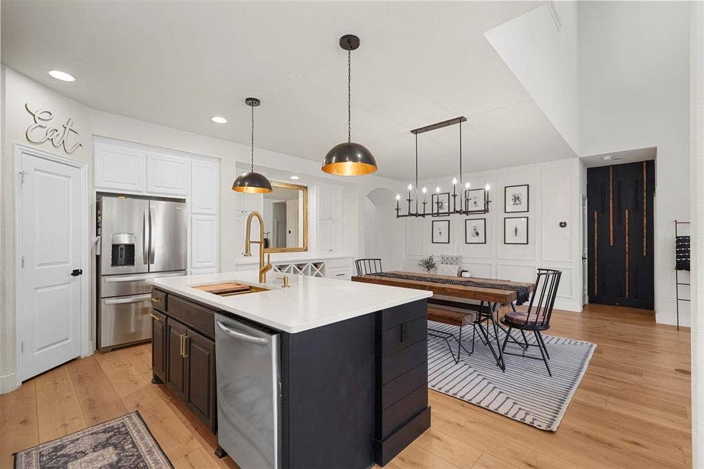 1506 Carnation Street, Celina, TX 75078 Open-concept kitchen and dining area featuring a kitchen island with a white countertop, gold-tone faucet, and pendant lighting