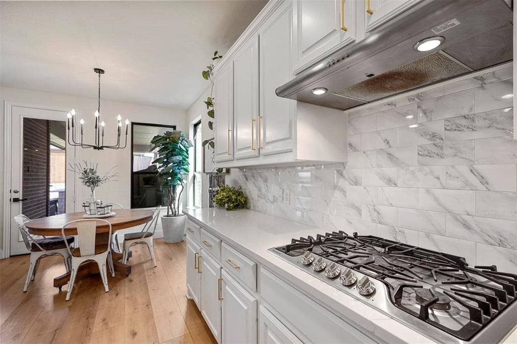 1506 Carnation Street, Celina, TX 75078 White upper and lower cabinetry with gold-finish hardware, stainless steel gas cooktop, quartz countertop, and white subway tile backsplash