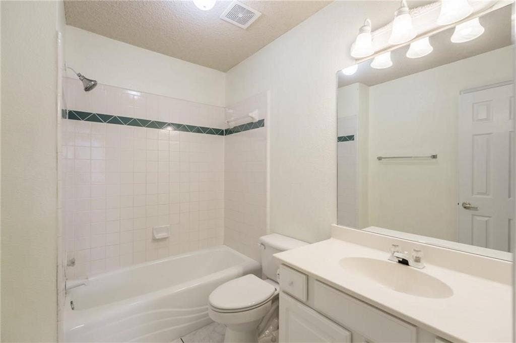 5000 Pointclear Court, Arlington, TX 76017 White tiled shower surround with decorative accent band