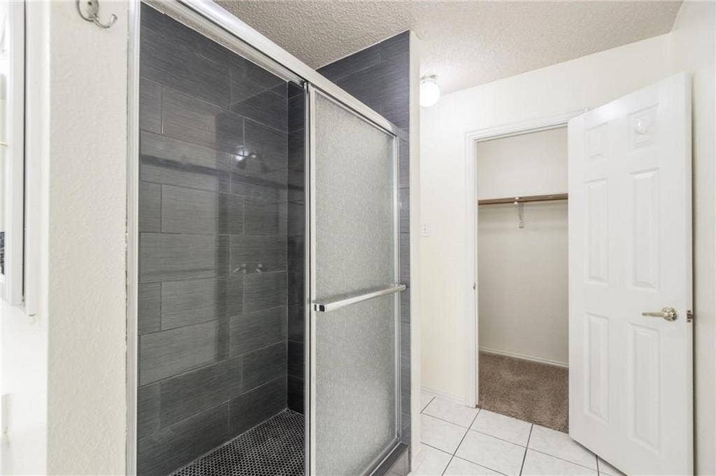 5000 Pointclear Court, Arlington, TX 76017 Enclosed shower with dark tile surround and sliding glass door