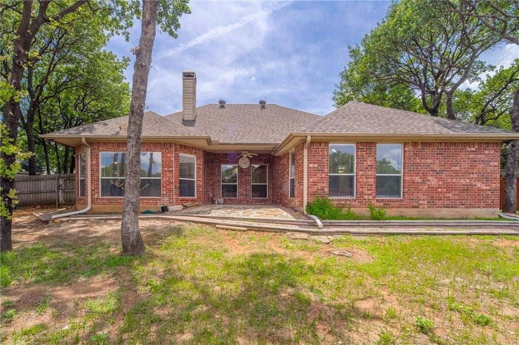 5000 Pointclear Court, Arlington, TX 76017 Brick exterior with multiple windows and a covered patio