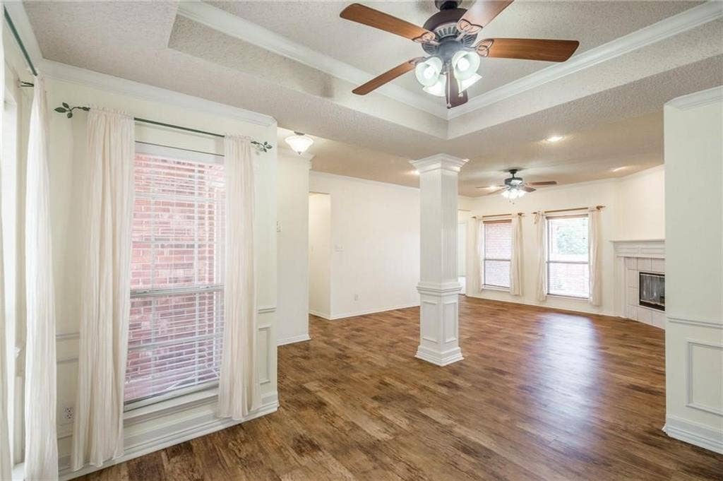 5000 Pointclear Court, Arlington, TX 76017 Wood-finish flooring throughout, tray ceiling with a ceiling fan, and a decorative column