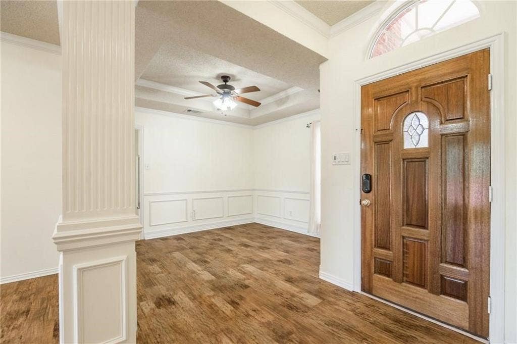 5000 Pointclear Court, Arlington, TX 76017 Wood-finish flooring throughout, decorative wainscoting, and a coffered ceiling with a ceiling fan