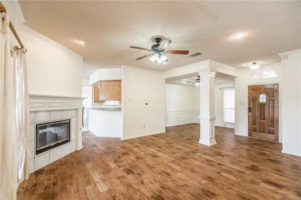 5000 Pointclear Court, Arlington, TX 76017 Wood-finish flooring throughout, tile-surround fireplace with mantel, decorative wood front door with arched transom, and recessed ceiling lighting