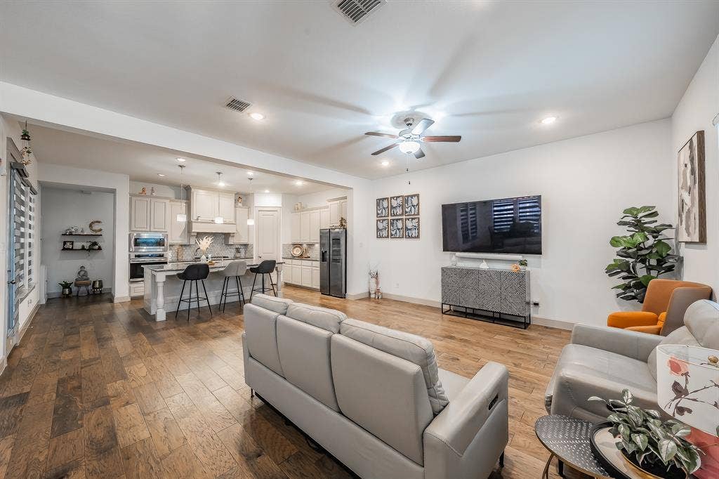 Open-concept living area featuring wood flooring, recessed lighting, and a ceiling fan