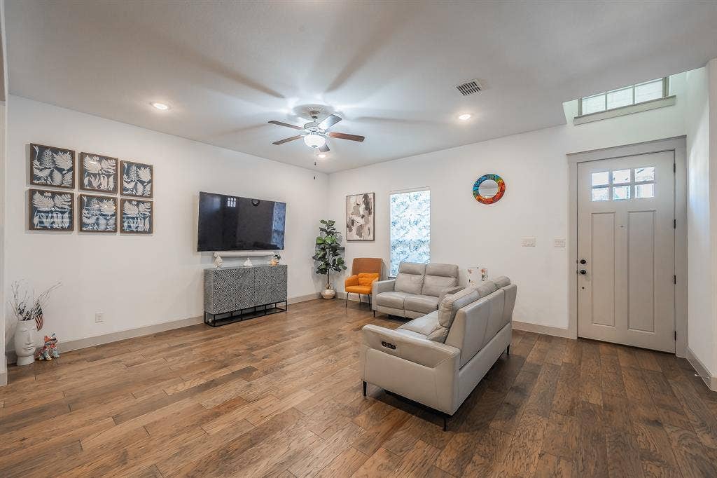 Open-concept living area featuring wood flooring, recessed lighting, and a ceiling fan