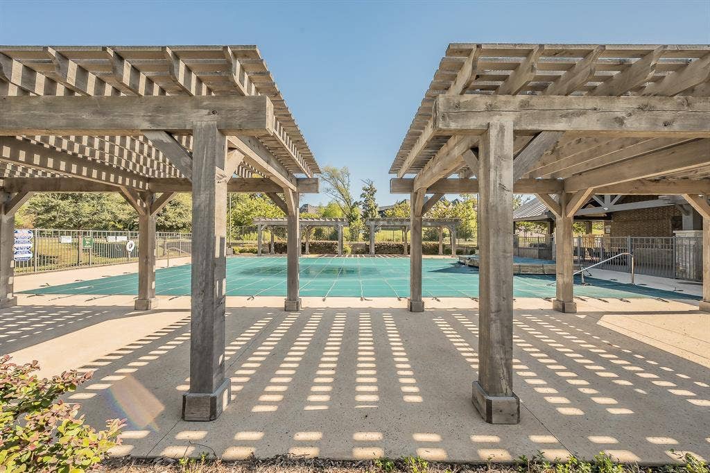 Pergolas, concrete patio, and fenced community swimming pool and grilling area with bathrooms for your enjoyment