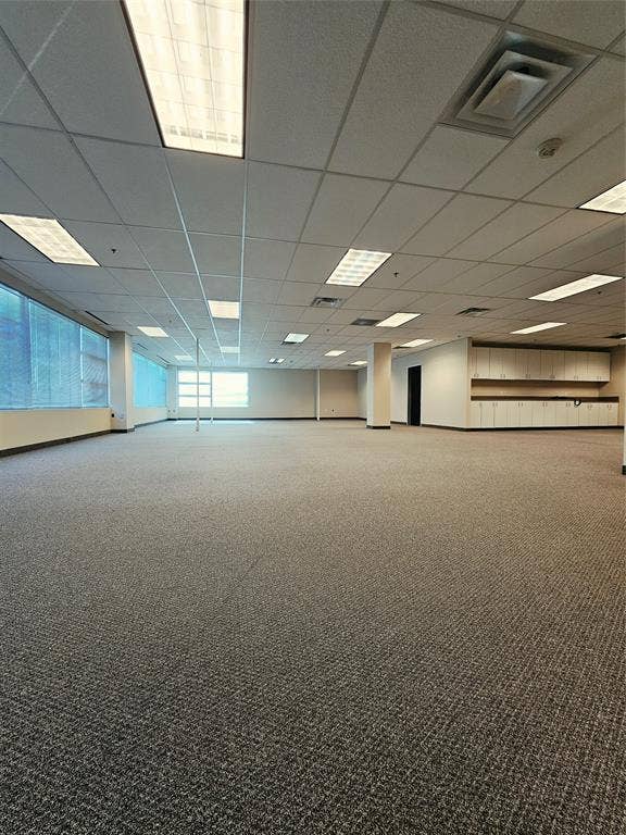 1675 Republic Parkway, #201A, Mesquite, TX 75150 Expansive open-concept room with dark gray patterned carpeting, drop ceiling with integrated lighting, and walls of windows