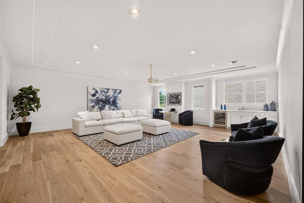 Recessed lighting, crown molding, wood-finish flooring, built-in wet bar, and multiple windows
