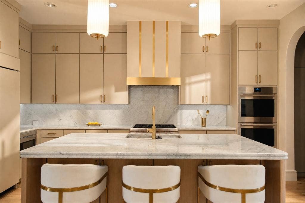 Expansive kitchen island with a stone countertop, featuring a built-in range and integrated sink