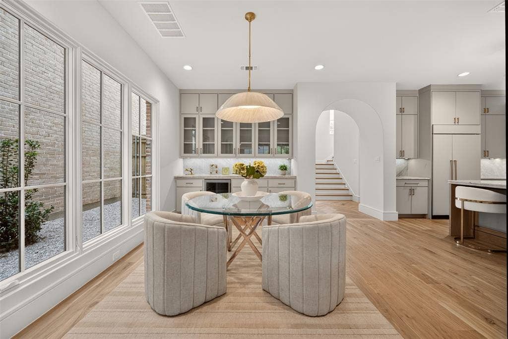 Expansive wood-finish flooring throughout, complemented by large paneled windows