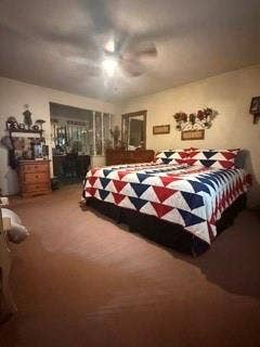 Carpeted bedroom with a ceiling fan, sconce lighting, and a window to an adjoining room