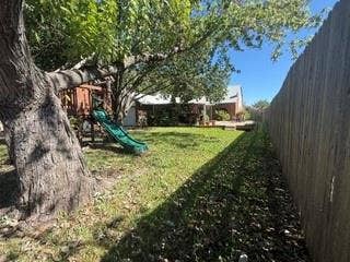 Expansive backyard featuring a manicured lawn, mature trees, and a privacy fence