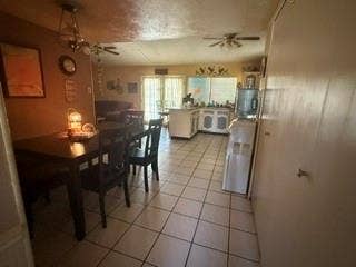 White tile flooring throughout, with a ceiling fan in the kitchen area