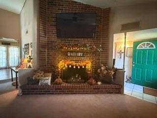 Brick fireplace with an extended hearth, vaulted ceiling, and a paneled front door with an arched transom window