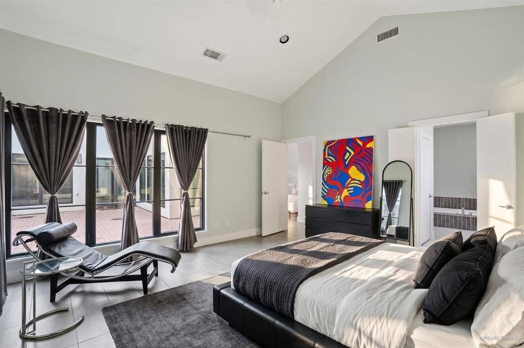 9123 Valley Chapel Lane, Dallas, TX 75220 Primary bedroom with double doors to the ensuite bath and natural light from the courtyard windows. Virtually staged.