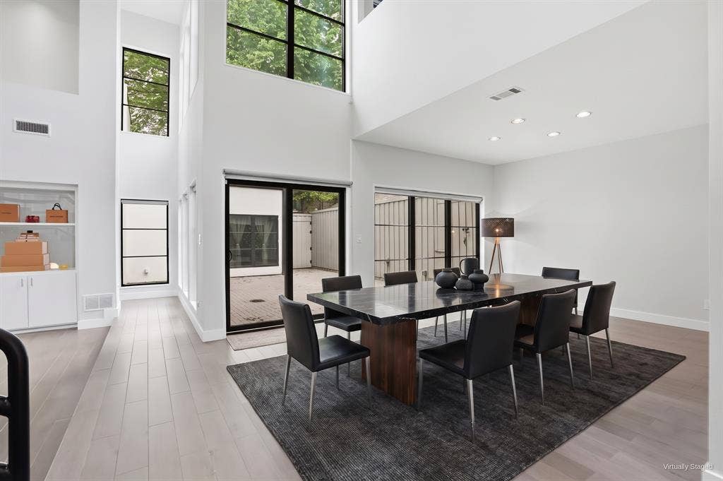 9123 Valley Chapel Lane, Dallas, TX 75220 Dining area off the great room with clerestory windows and black-framed sliding glass doors that open to the courtyard. Virtually staged.