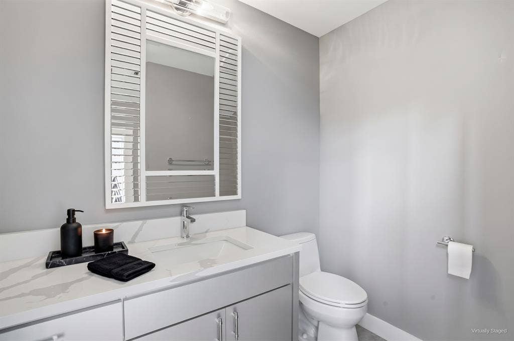 9123 Valley Chapel Lane, Dallas, TX 75220 Powder room with a marble-look vanity top and modern fixtures. Virtually staged.