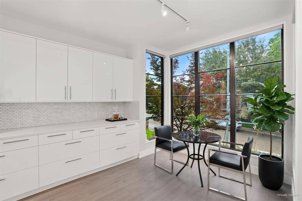9123 Valley Chapel Lane, Dallas, TX 75220 Breakfast nook wrapped in floor-to-ceiling corner windows with views of the trees. Virtually staged.