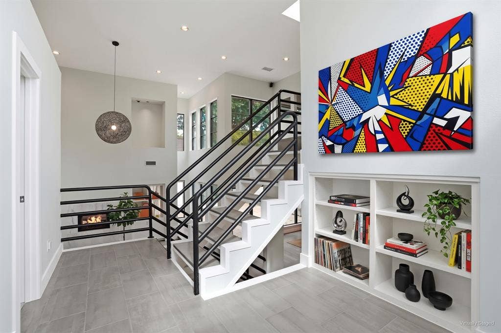 9123 Valley Chapel Lane, Dallas, TX 75220 Upper landing with built-in bookshelves, a globe pendant, and an open staircase to the third-floor bedrooms. Virtually staged.