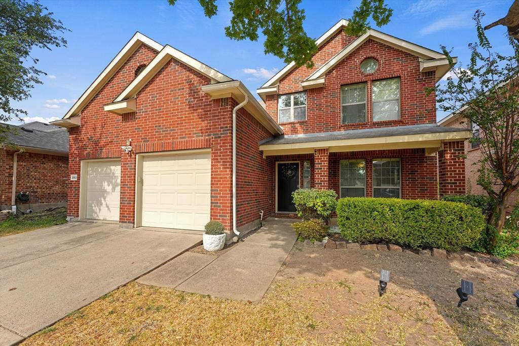 2053 Lake Trail Drive, Heartland, TX 75126 Brick exterior with a covered porch, two-car garage, and established front landscaping