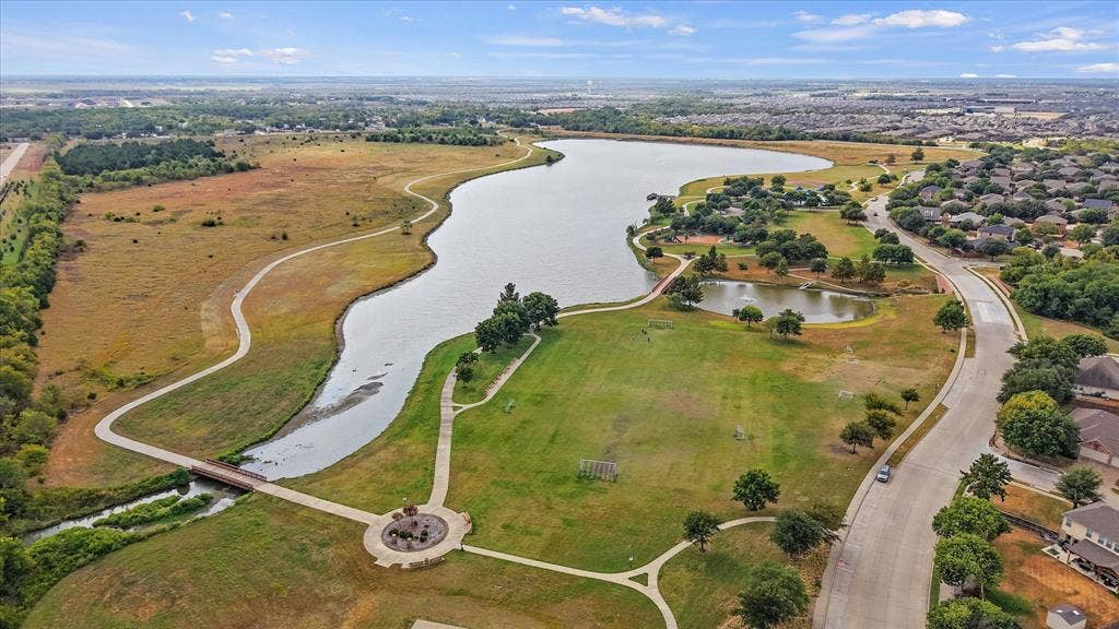 2053 Lake Trail Drive, Heartland, TX 75126 Expansive lake frontage with a pedestrian bridge, walking paths, and surrounding green spaces